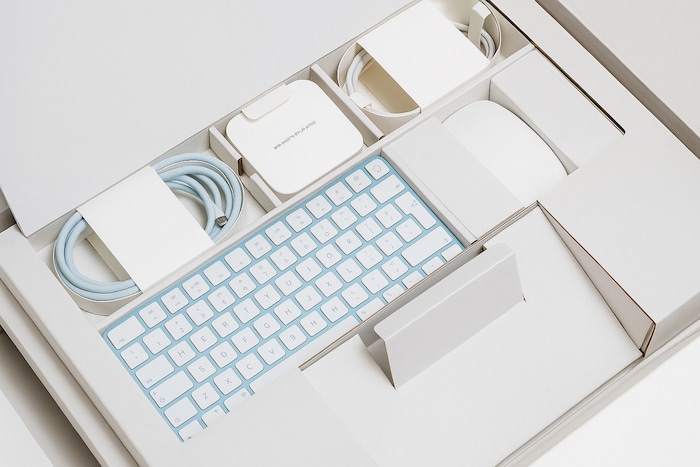 Clavier Apple, câble d’alimentation et souris Magic Mouse dans la boîte d’origine d’un iMac