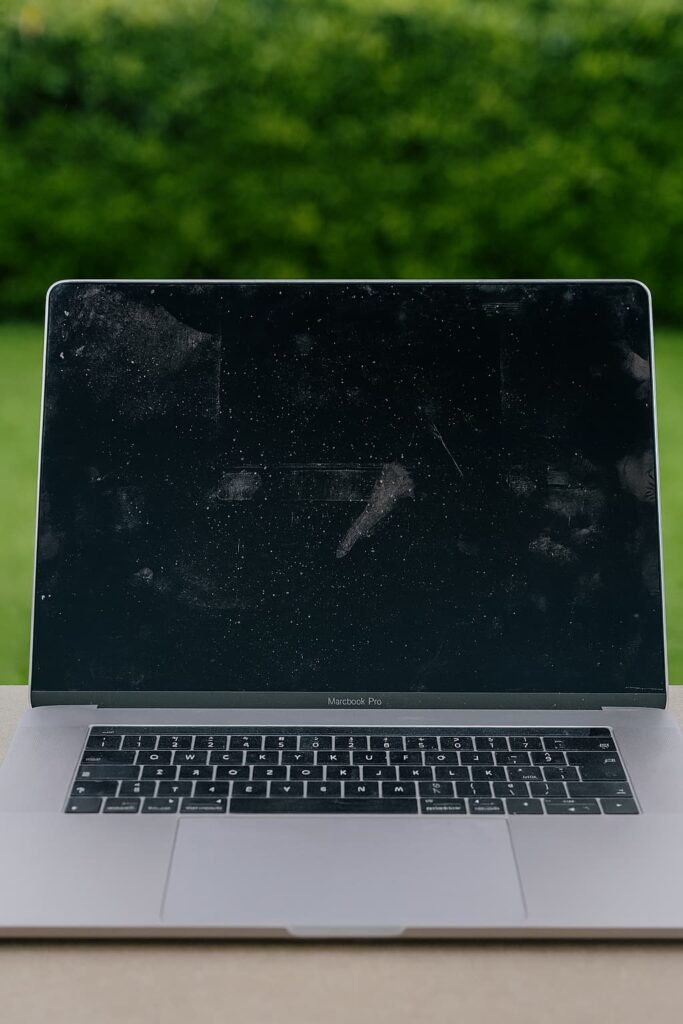Écran MacBook Pro couvert de traces de doigts et de poussière, illustrant un mauvais nettoyage