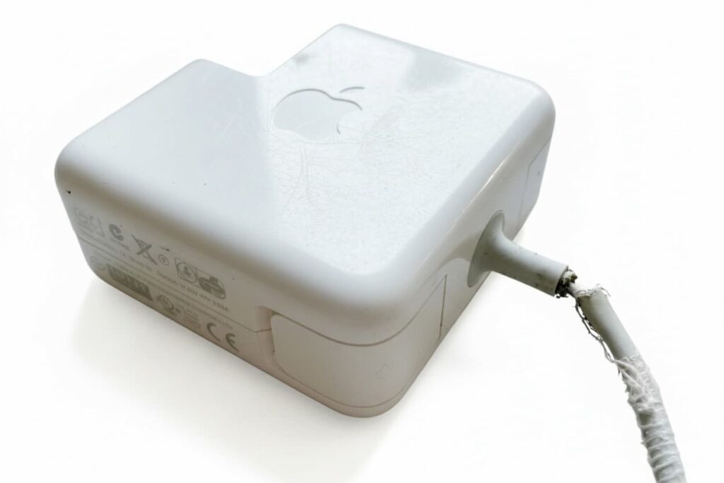 Chargeur Apple MagSafe avec câble effiloché et gaine abîmée, source possible de panne sur MacBook