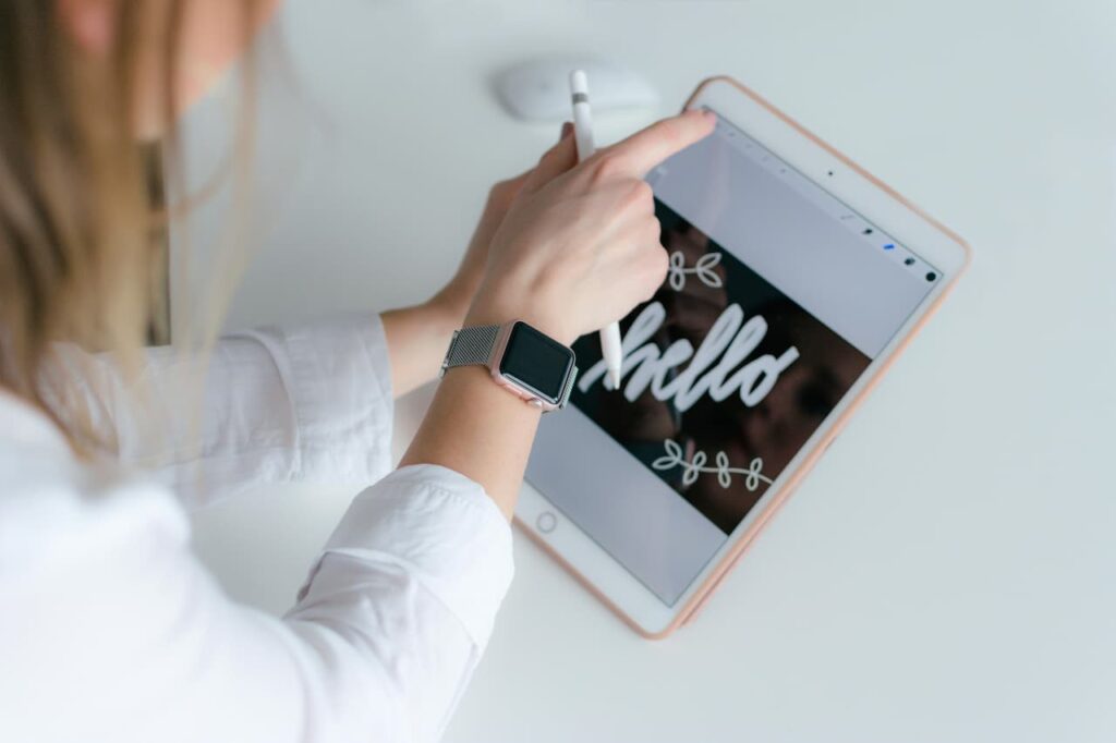 Femme dessinant sur un iPad reconditionné avec un Apple Pencil, illustrant l'usage créatif d'une tablette Apple.
